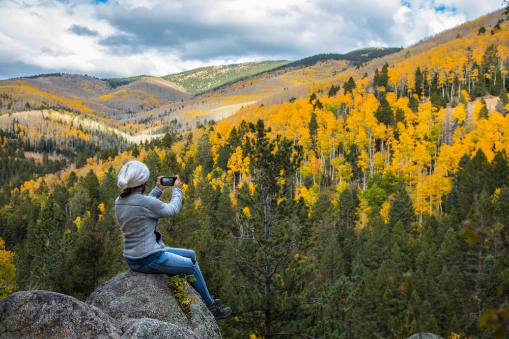 Woman enjoying colorful foliage while taking New Mexico Hikes in the fall